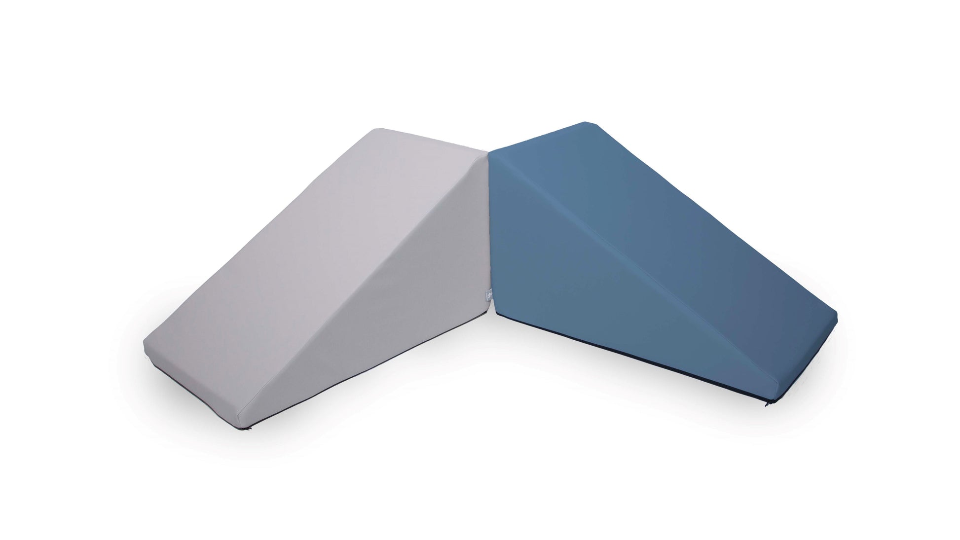 Two Mega Wedge Play Triangles from Foamnasium are placed side by side, creating a V-shape. One cushion is light gray, and the other is blue. These cushions have a smooth texture and are CertiPUR-US certified, designed to provide durable support.